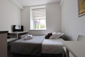 Habitación blanca con cama y ventana en Mini dzīvoklis-atbilstoša cena, en Riga