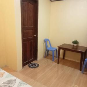 a room with a desk and a blue chair and a table at JANHOUR PLACE in San Vicente