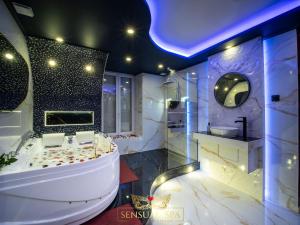 a large bathroom with a tub and a sink at Sensual SPA- Love ROOM Jacuzzi Hammam Terrasse in Nancy