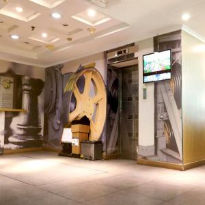 Tamarin Hotel Jakarta manage by Vib Hospitality Management في جاكرتا: غرفة بها تلفزيون وعجلة كبيرة على الحائط