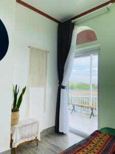 a bedroom with a window with a view of the ocean at Gió Homestay and Coffee in Ấp Khánh Phước (1)