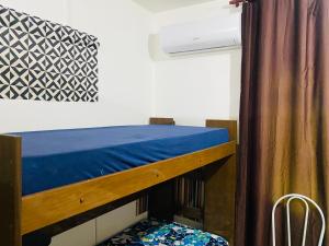 サンパウロにあるCasa completa 60m com 3 quartos, 3 ar-condicionados climatizados, SP São Pauloのカーテン付きのドミトリールームの二段ベッド1台分です。