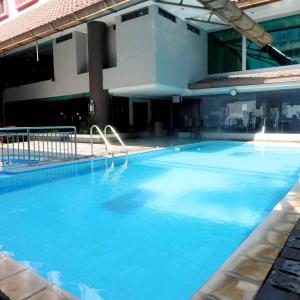 Tamarin Hotel Jakarta manage by Vib Hospitality Management في جاكرتا: مسبح ازرق كبير امام مبنى