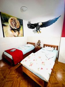 2 camas en una habitación con un águila en la pared en Casa BB&Djassi, en Ponta do Sol