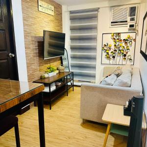 a living room with a couch and a tv at Emotera Place @ Arezzo Place Davao in Davao City