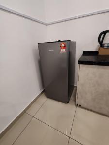 a small refrigerator in a corner of a room at Cozy 2room 6pax @ Menara Sentral in Bukit Mertajam