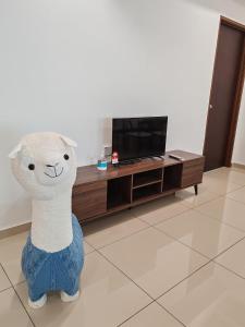 a stuffed lamb is standing in a living room at Cozy 2room 6pax @ Menara Sentral in Bukit Mertajam