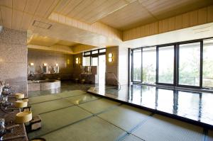 a large room with a swimming pool in a building at Fufurotenburonoyado Ginsyou in Ibusuki