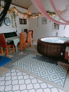 a room with a tub and a table and chairs at The White Dove Bed and Breakfast with Glamping Newark showground in Newark-on-Trent