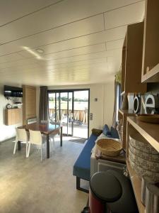 Auvergne chalets Sancy في Bagnols: غرفة معيشة مع أريكة زرقاء وطاولة