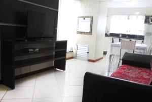 - un salon avec un canapé et une télévision dans l'établissement Cantinho Aconchegante Morada do Sol, à Piratuba