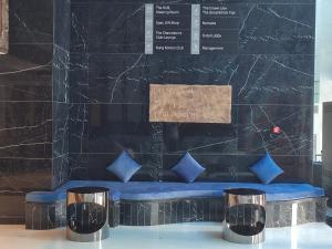 um quarto com um banco com almofadas azuis em Social Hotel formerly Byblos em Dubai