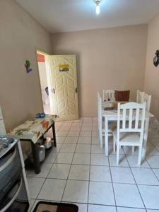 cocina con mesa, sillas y puerta en Casa de praia para temporada espaço inteiro Putiri ES, en Santa Cruz