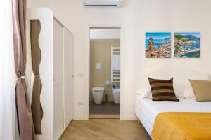 a white bedroom with a bed and a bathroom at Palazzo Olivieri Amalfi Coast in Salerno