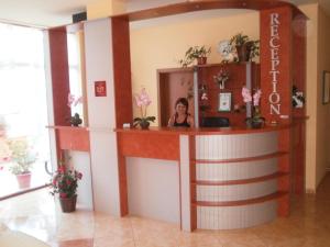 a woman standing at a reception desk in a room at EUROPA Guest House in Kiten