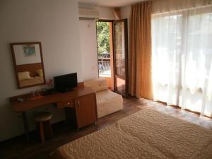 a living room with a desk with a computer and a window at EUROPA Guest House in Kiten