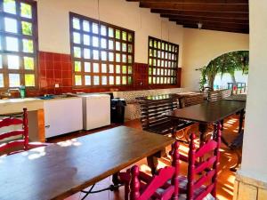 Un comedor con mesas y sillas y ventanas. en Villa La Gran Duquesa, en Playa de San Juan
