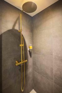 a shower with a shower head in a bathroom at Historical 80m2 Retreat with Sauna option in Eindhoven