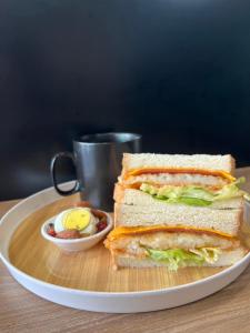 un sándwich en un plato junto a una taza de comida en Fengjia JinRui Hotel, en Taichung