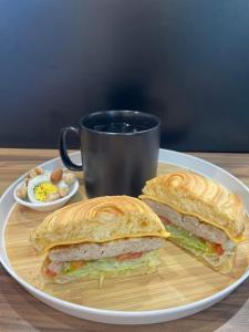 a sandwich on a plate next to a cup of coffee at Fengjia JinRui Hotel in Taichung
