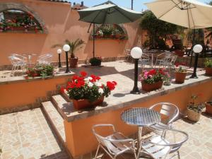 a patio with a table and chairs and flowers at EUROPA Guest House in Kiten