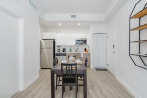 a kitchen and dining room with a table and chairs at Comfortable Apartment in Charming Wynwood in Miami