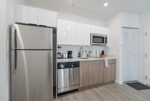 a kitchen with a refrigerator and a microwave at Comfortable Apartment in Charming Wynwood in Miami