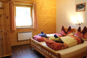 um quarto com uma cama com muitas almofadas em Murtalhütte em Muhr