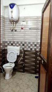 a bathroom with a toilet and a water tank at त्रिnity homestay in Kasol
