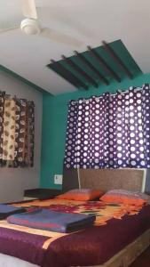 1 dormitorio con 1 cama con paredes azules en 3 BHK Villa (Papai Bungalow) behind Mapro Garden, en Panchgani