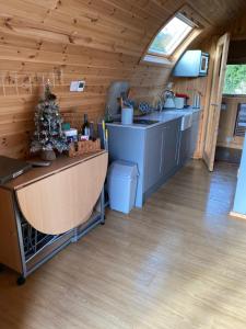 una cocina en una cabaña de madera con barra en Garden Cottage Glamping Pod en Boncath