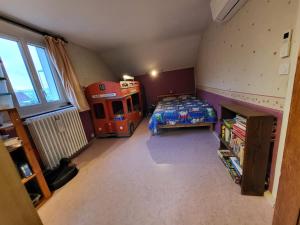 1 dormitorio con cama y autobús rojo en Maison JO 2024 en Guyancourt