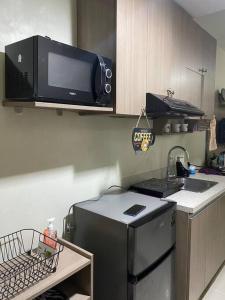 La cuisine est équipée d'un réfrigérateur en acier inoxydable et d'un four micro-ondes. dans l'établissement Horizon101 studio gem, à Cebu