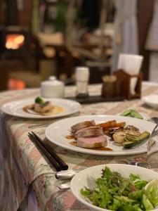 a table with two plates of food on it at Garden Pension Obergurgl in Hakuba