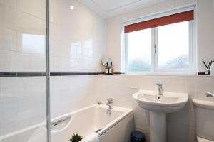 ein Badezimmer mit einem Waschbecken, einer Badewanne und einem WC in der Unterkunft Fennec 4-BR Detached House, Sleeps 6, Free Parking in Cambridge