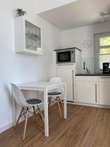 uma cozinha branca com uma mesa e cadeiras em Apartment Nr. 2 Bad Laasphe Altstadt em Bad Laasphe
