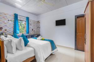 a bedroom with a bed and a window and a tv at The Sequeira Goa in Majorda