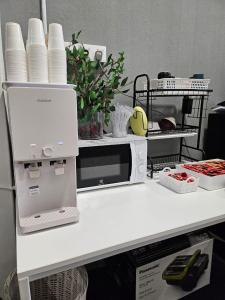 a white counter top with a microwave and dishes at Le Melur Single Bed in George Town