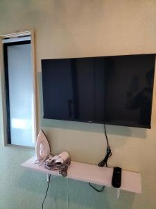 a flat screen tv on a wall with a shelf at Le Melur Single Bed in George Town