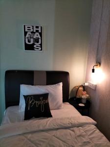 a bed with a black and white pillow on it at Le Melur Single Bed in George Town