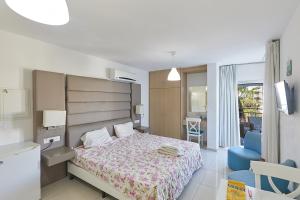 um quarto com uma cama e uma cadeira azul em Napa Hera 's Nest em Agia Napa