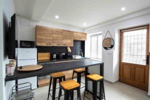 a kitchen with a counter and some stools in it at Appartement jacuzzi hammam in Francheville