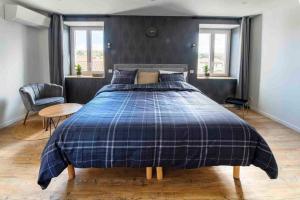 ein Schlafzimmer mit einem Bett mit einer blauen karierten Decke in der Unterkunft Appartement jacuzzi hammam in Francheville