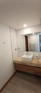 La salle de bains est pourvue d'un lavabo et d'un grand miroir. dans l'établissement North Beach GHF, à Costa Esmeralda