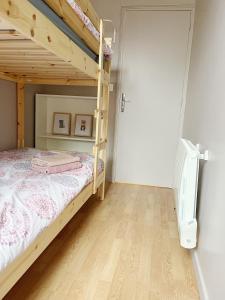 - une chambre avec des lits superposés et du parquet dans l'établissement Petite maison proche du métro, à Bagnolet