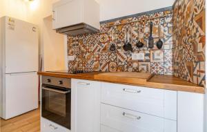 a kitchen with white cabinets and a tile wall at Cozy Apartment In Arcos De La Frontera in Arcos de la Frontera