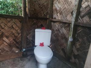 a toilet with two bows on top of it at Imaio home stay in Ipenyen