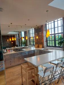 duża kuchnia ze stołem i krzesłami w obiekcie Converted factory loft apartment w Bristolu