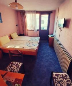 a hotel room with a bed and a table and chairs at Family Hotel Santo Bansko in Bansko