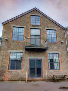 a brick building with a balcony and a deck at Converted factory loft apartment in Bristol